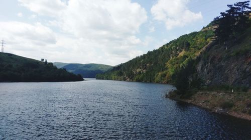 Scenic view of river amidst trees against sky
