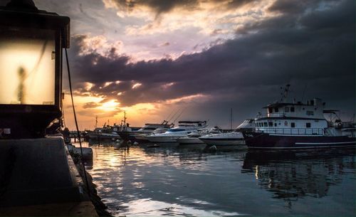 Boats in harbor at sunset