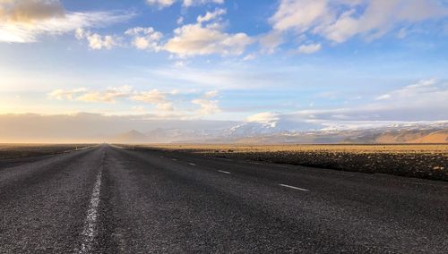 Road by landscape against sky