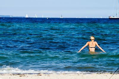 Rear view of woman wearing bikini in sea