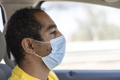 Close-up portrait of an middle eastern msn driving with a face mask