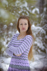 Portrait of young woman standing in forest