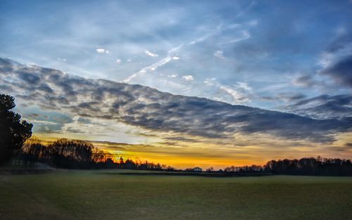 Scenic view of silhouette field against sky during sunset