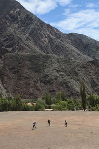 Group of people on mountain road against sky