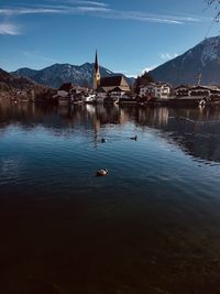 View of lake by buildings against sky