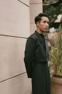 Young man standing against wall