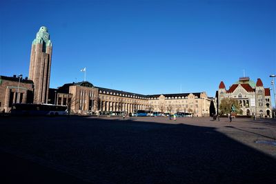 Buildings in city against clear blue sky