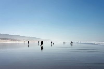 People at beach against sky