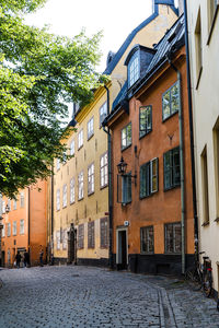 Residential buildings by street against sky