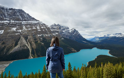 Rear view of woman looking at mountains against sky