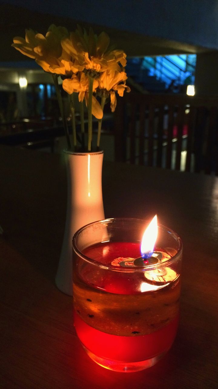 flame, burning, candle, fire - natural phenomenon, indoors, heat - temperature, illuminated, glowing, lit, close-up, candlelight, table, glass - material, focus on foreground, fire, night, dark, flower, tea light, still life