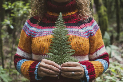 Midsection of woman standing in forest