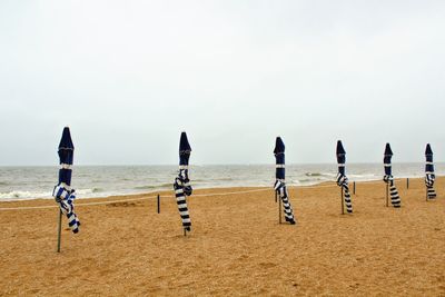 People on beach against clear sky