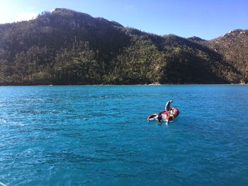 People on boat in sea against sky