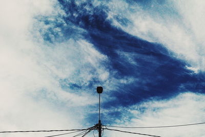 Low angle view of power lines against cloudy sky