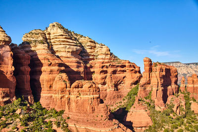 Rock formations on mountain against clear blue sky