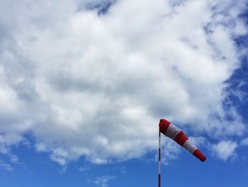 Low angle view of poles against cloudy sky