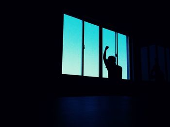 Low angle view of silhouette person standing at window