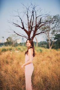 Portrait of young woman standing on field