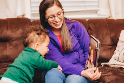 Smiling mother and son talking on video call at home