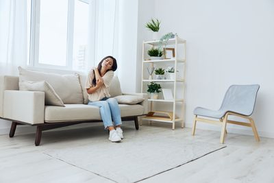 Woman sitting on sofa at home