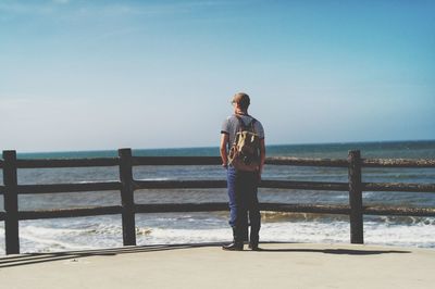 Rear view of man standing against sea