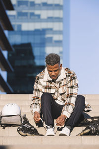 Latino ethnic man preparing to skate in the city park person