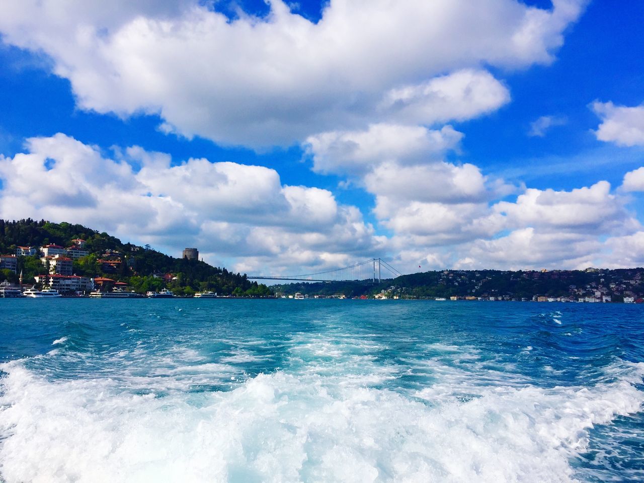 water, sea, sky, building exterior, cloud - sky, waterfront, blue, architecture, built structure, scenics, city, beauty in nature, cloud, cityscape, cloudy, nature, mountain, wave, residential building, outdoors