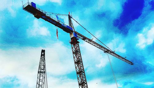 Low angle view of crane against cloudy sky