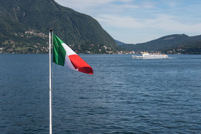 Italian flag on sea against mountain range. italian flag on lake lago maggiore