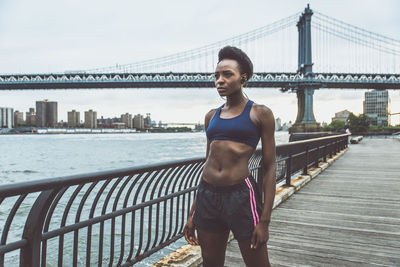 Woman exercising on bridge in city