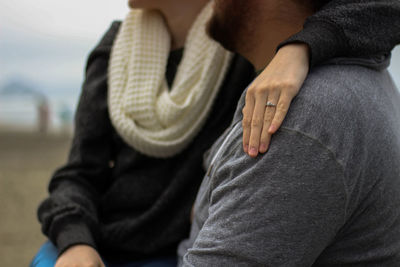 Midsection of couple sitting outdoors