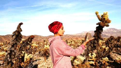 Woman standing on mountain against sky