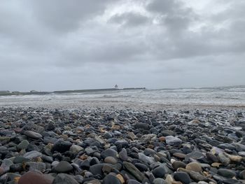 Rocks on beach against sky