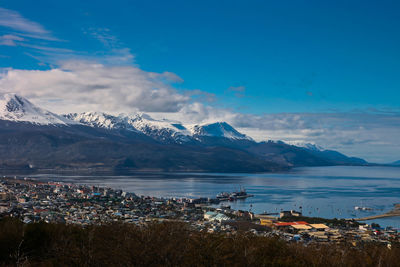 Scenic view of sea by mountain against sky