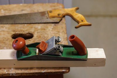 Planer, saw and wooden block on a stool