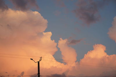 Electricity pylon against sky at sunset