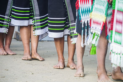 Low section of people wearing traditional clothing standing outdoors