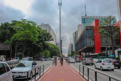 Cars on road amidst buildings in city against sky