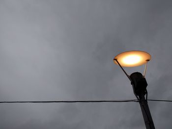 Low angle view of illuminated street light against sky