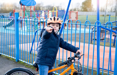 Portrait of young woman riding bicycle on railing