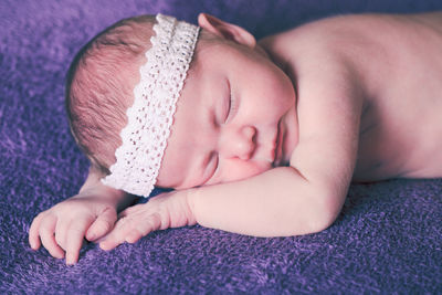 Close-up of baby sleeping on bed