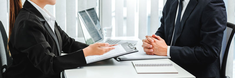 Midsection of man and woman with text on table