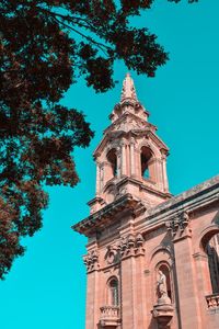 Low angle view of trees and building against sky