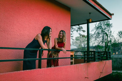 Lesbian couple leaning in balcony