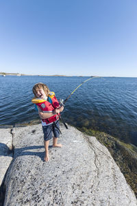 Happy boy fishing in sea