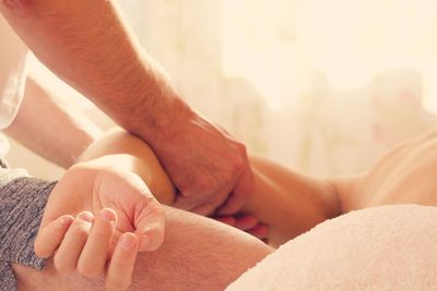 Midsection of therapist massaging woman at spa