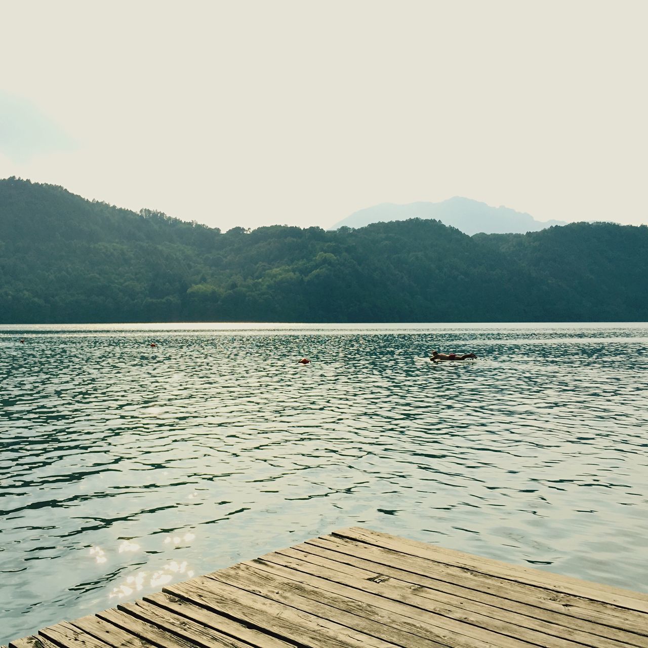 water, mountain, tranquil scene, lake, scenics, tranquility, bird, mountain range, beauty in nature, reflection, nature, clear sky, sky, animal themes, idyllic, animals in the wild, wildlife, outdoors, rippled, non-urban scene