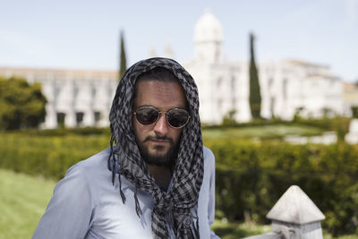 Portrait of man wearing sunglasses and scarf in city