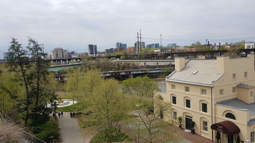 High angle view of buildings by river against sky